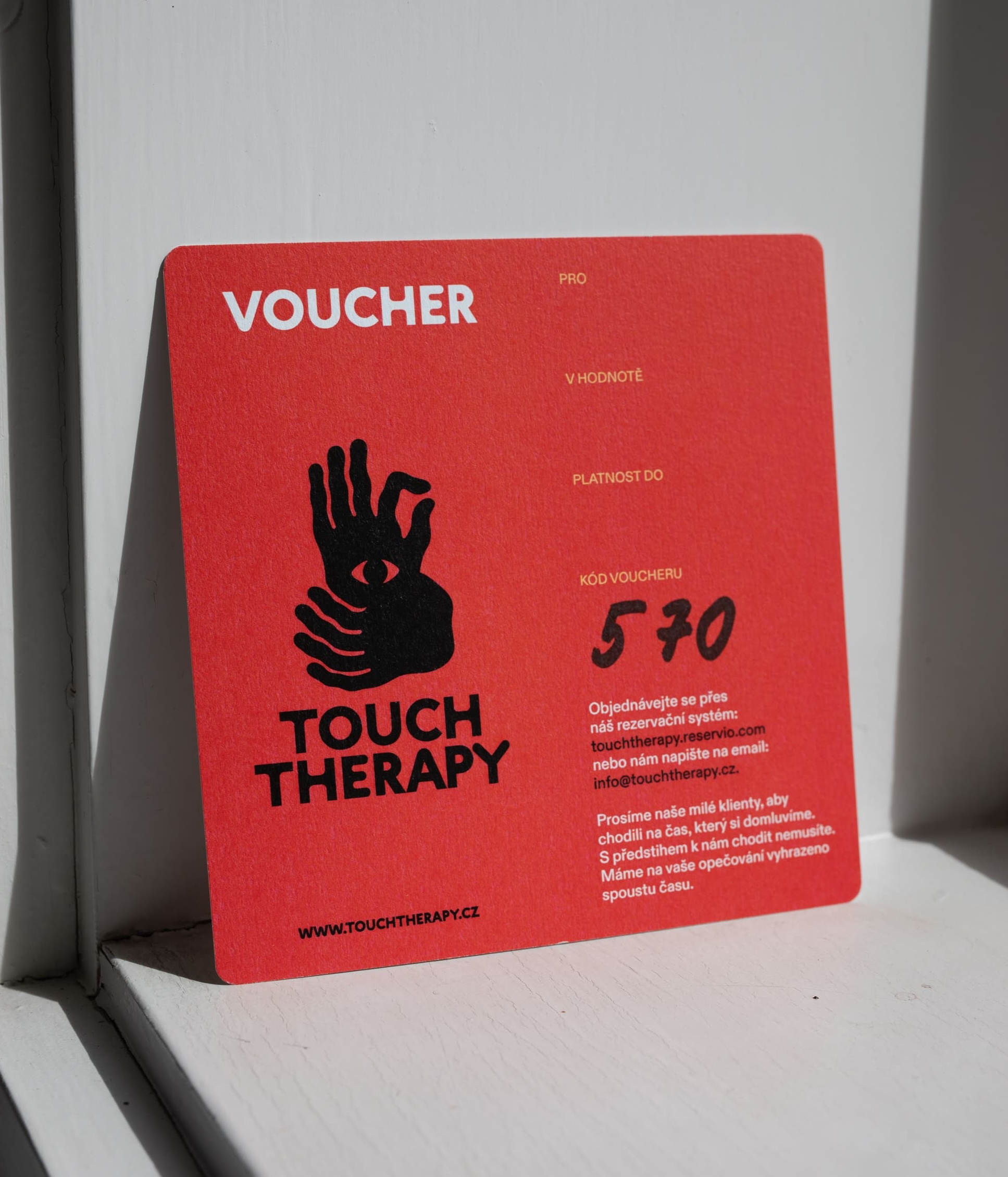 ruka drží poukázku na terapii do Touch Therapy s platností 1 rok